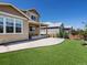 Backyard with artificial grass, patio, covered porch, and manicured landscaping at 800 Boulder Peak Ave, Erie, CO 80516