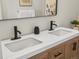 Close up on bathroom vanity with double sinks, black fixtures, and modern, white countertop at 800 Boulder Peak Ave, Erie, CO 80516