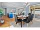 Light-filled dining room open to kitchen featuring table with seating, modern light fixture and backyard views at 800 Boulder Peak Ave, Erie, CO 80516