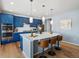 Modern kitchen with blue cabinets, stainless steel appliances, and large quartz island at 800 Boulder Peak Ave, Erie, CO 80516