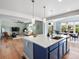 Open-concept kitchen features island with seating, stainless sink, pendant lighting, and views of living and dining areas at 800 Boulder Peak Ave, Erie, CO 80516