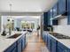 Bright kitchen boasts stainless appliances, blue cabinets, white countertops and island with sink at 800 Boulder Peak Ave, Erie, CO 80516