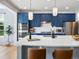 Eat-in kitchen features a spacious center island with seating, stainless appliances and white countertop at 800 Boulder Peak Ave, Erie, CO 80516