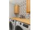 Bright laundry room featuring modern appliances, butcher block countertop, and updated design at 800 Boulder Peak Ave, Erie, CO 80516
