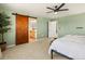 Bright bedroom features barn door to main bathroom, plush carpet and ceiling fan at 800 Boulder Peak Ave, Erie, CO 80516