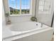 The main bathroom boasts a soaking tub with large window and stylish accents at 800 Boulder Peak Ave, Erie, CO 80516