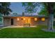 Well-manicured backyard with lawn, mature trees, and patio with outdoor dining furniture at 10844 W 68Th Ave, Arvada, CO 80004