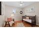 Cozy bedroom features hardwood floors, a ceiling fan, and abundant natural light from the window at 10844 W 68Th Ave, Arvada, CO 80004