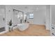 A modern bathroom with a freestanding tub, glass shower, neutral colors, and a view at 8700 Lost Lake Dr, Franktown, CO 80116