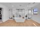 Bright bathroom featuring a soaking tub, glass showers, light wood floors, and modern fixtures at 8700 Lost Lake Dr, Franktown, CO 80116