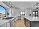 Modern kitchen with stainless steel appliances, white cabinetry, hardwood flooring, and a large window with great views at 8700 Lost Lake Dr, Franktown, CO 80116