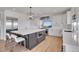 Bright kitchen with white cabinets, stainless steel appliances, a large kitchen island and a pendant light fixture at 8700 Lost Lake Dr, Franktown, CO 80116