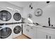Well-organized laundry room featuring modern washer/dryer units, sleek countertops, and ample storage space at 8700 Lost Lake Dr, Franktown, CO 80116