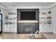 Modern living room with fireplace, floating shelves, wood flooring, and white cabinets at 8700 Lost Lake Dr, Franktown, CO 80116