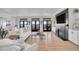 Open living area with hardwood flooring, comfortable seating, a fireplace, and access to outdoor patios with views at 8700 Lost Lake Dr, Franktown, CO 80116