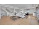 Bright living room with white sofa, hardwood floors, a modern light fixture, and open floorplan at 8700 Lost Lake Dr, Franktown, CO 80116