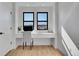Bright home office with modern built-in desk, chair, and natural light from two windows at 8700 Lost Lake Dr, Franktown, CO 80116