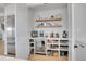 Walk-in pantry with floating wood shelves, a beverage fridge, and built-in shelves at 8700 Lost Lake Dr, Franktown, CO 80116