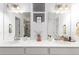 Elegant bathroom showcasing double sinks, white cabinetry, and a glass enclosed shower at 509 High Point Dr, Longmont, CO 80504