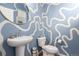 This powder room features blue walls with a modern design, sink, and toilet at 509 High Point Dr, Longmont, CO 80504