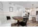 Cozy dining nook with a wooden table, built-in bench seating, and stylish decor and adjacent kitchen at 509 High Point Dr, Longmont, CO 80504