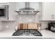 This gourmet kitchen boasts stainless steel appliances, a modern range hood, and stylish white cabinetry at 509 High Point Dr, Longmont, CO 80504