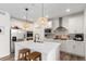 Open kitchen with stainless steel appliances, a large center island, and modern lighting fixtures for a warm touch at 509 High Point Dr, Longmont, CO 80504