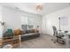 Bright living room featuring a gray couch, modern lighting, and a large window at 509 High Point Dr, Longmont, CO 80504