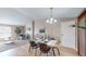 Cozy dining area featuring hardwood floors, a modern chandelier, and seamless transition to the living room with fireplace at 11813 Bellaire Cir, Thornton, CO 80233