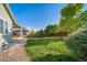 A green backyard with rock landscaping, view of covered patio and wooden fence at 14035 Touchstone St, Parker, CO 80134