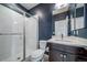 Modern bathroom featuring a white shower, toilet, vanity, and dark blue wall at 14035 Touchstone St, Parker, CO 80134