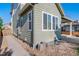 Charming home exterior featuring light green siding, white trim windows, and a cozy rock garden along the side at 14035 Touchstone St, Parker, CO 80134