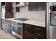Close-up of kitchen with stainless steel appliances, dark cabinets, and a white countertop at 14035 Touchstone St, Parker, CO 80134