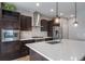 Close-up of kitchen with stainless steel appliances, dark cabinets, and a large center island with white countertop at 14035 Touchstone St, Parker, CO 80134