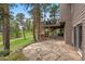 Backyard with stone patio and elevated deck nestled in pine trees at 29962 Troutdale Ridge Rd, Evergreen, CO 80439