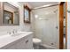 Modern bathroom featuring sleek vanity with dual sinks, a glass-enclosed shower, and contemporary fixtures at 29962 Troutdale Ridge Rd, Evergreen, CO 80439
