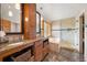 Luxurious bathroom featuring dual vanities, granite counters, soaking tub, and glass-enclosed shower at 29962 Troutdale Ridge Rd, Evergreen, CO 80439