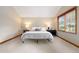 Inviting bedroom with plush carpet, neutral walls, and black nightstands lit by lamps on either side of bed at 29962 Troutdale Ridge Rd, Evergreen, CO 80439