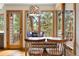 Bright dining area with floor-to-ceiling windows offering scenic forest views and access to a deck at 29962 Troutdale Ridge Rd, Evergreen, CO 80439