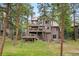 Exterior shot of a multi-story home with multiple decks surrounded by mature trees and green space at 29962 Troutdale Ridge Rd, Evergreen, CO 80439