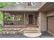 Inviting home entrance featuring a cozy covered porch and stone steps leading to the front door at 29962 Troutdale Ridge Rd, Evergreen, CO 80439