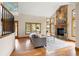 Spacious living room boasts a stone fireplace, natural light, and beautiful hardwood floors at 29962 Troutdale Ridge Rd, Evergreen, CO 80439