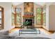 Bright living room featuring a stone fireplace, large windows, and hardwood floors, perfect for relaxing at 29962 Troutdale Ridge Rd, Evergreen, CO 80439