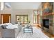 Bright living room with large windows, a stone fireplace, and hardwood floors for a cozy atmosphere at 29962 Troutdale Ridge Rd, Evergreen, CO 80439