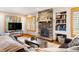 Cozy living room featuring a stone fireplace, custom built-ins, and comfortable leather seating at 29962 Troutdale Ridge Rd, Evergreen, CO 80439