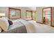 Spacious main bedroom featuring large windows, sliding door to the deck, and en-suite bathroom at 29962 Troutdale Ridge Rd, Evergreen, CO 80439