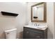 Stylish powder room featuring a vanity with gray cabinetry, a large mirror, and contemporary fixtures at 29962 Troutdale Ridge Rd, Evergreen, CO 80439