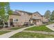 Inviting exterior view of tan two-story townhome, showcasing landscaped front yard and cozy outdoor space at 1601 Great Western Dr # D3, Longmont, CO 80501