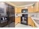 Efficient kitchen with black appliances, light cabinets, and modern finishes at 1601 Great Western Dr # D3, Longmont, CO 80501