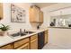 The kitchen features a double sink, wood cabinets, modern dishwasher, and pass-through bar to the living room at 1601 Great Western Dr # D3, Longmont, CO 80501